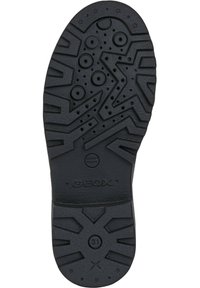 Suola di scarpa in gomma nera con battistrada a motivo, caratterizzata da perforazioni circolari e un logo. Il design include forme geometriche e stelle.
