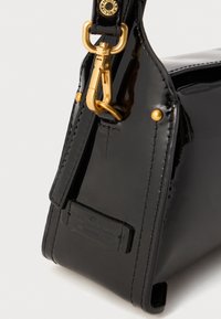 Borsa in pelle verniciata nera con design strutturato, dotata di una chiusura color oro, dettagli di cucitura e un'etichetta impresso sul lato.