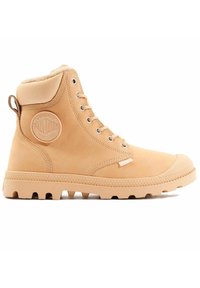 Botín de cuero beige hasta el tobillo con suela de goma texturizada, punta redonda, cordones tonales y un logotipo en parche en el costado. Forro de forro polar en el cuello.