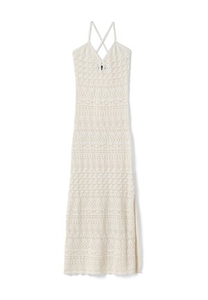 Robe maxi blanche en crochet avec bretelles fines croisées, encolure en V et motifs de losanges et de fleurs sur toute la robe.