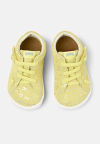 Scarpe in suede giallo con pois argentati, punta rotonda, design con lacci e suole in gomma bianca. Etichetta del marchio visibile sulla linguetta.