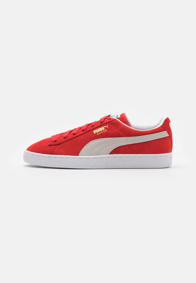 Red suede sneaker with white rubber sole, featuring a beige side stripe and gold branding. Laces and padded collar are included.