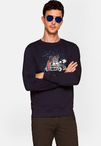 Granatowa bluza z nadrukiem graficznym przedstawiającym klasyczny samochód, deskę surfingową i palmy; ściągacze na mankietach i u dołu, miękka mieszanka bawełny.