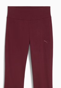 Bordeaux atletische legging met een brede tailleband en een gladde textuur. Kenmerkt zich door een subtiele Puma-logo aan de linkerkant.