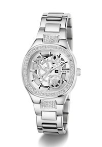 Montre-bracelet en argent avec un cadran en squelette, dotée d'une lunette ornée de cristaux, d'un bracelet en métal à maillons et de détails d'engrenages complexes au centre.