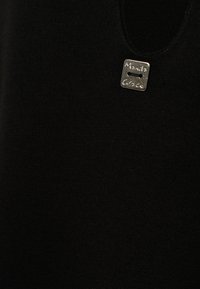 Maglione nero a maglia con scollatura rotonda e etichetta quadrata in argento con il logo "Manila Grace" impresso. Il tessuto ha una texture liscia.