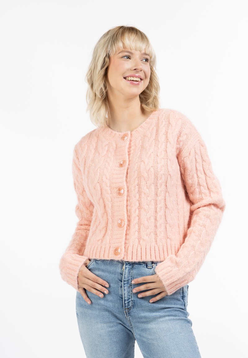 Ljusrosa kabelstickad cardigan med rund halsringning, sex knappar och ribbat avslut. Den har långa ärmar och en mjuk, texturerad yta.