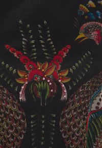 Tessuto nero con ricami intricati di fiori e uccelli in colori vivaci, adornato con strass e motivi dettagliati.