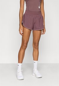 Μπορντό αθλητικό σορτς με λευκή διακοσμητική ρίγα, ελαστική μέση και φαρδιά γραμμή, συνδυασμένα με λευκά αθλητικά παπούτσια και κάλτσες.