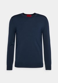 Maglione a maniche lunghe di colore blu navy realizzato in materiale morbido, con scollo rotondo e polsini e orlo a coste. Etichetta visibile sul colletto.