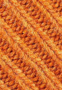 Tessuto testurizzato di un arancione vibrante, caratterizzato da un motivo a coste diagonali con fibre morbide e pelose, evidenziando il suo design lavorato a maglia e il calore.