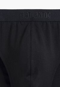 Czarne majtki wykonane z gładkiego materiału z szerokim pasem, na którym znajduje się wytłaczany tekst "ATLANTIC". Bezszwowe boki i elastyczne dopasowanie.