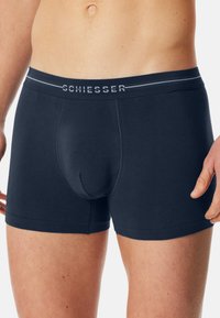 Mörkblå bomullskalsonger för män med en figurnära design, elastisk midjeband med varumärket "Schiesser" och subtila texturerade mönster.