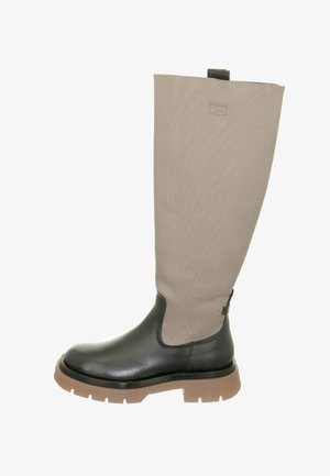 Hoher Stiefel mit schwarzem Lederfuß und brauner Gummisohle, beigem Stoffschaft und Zuglasche oben hinten.