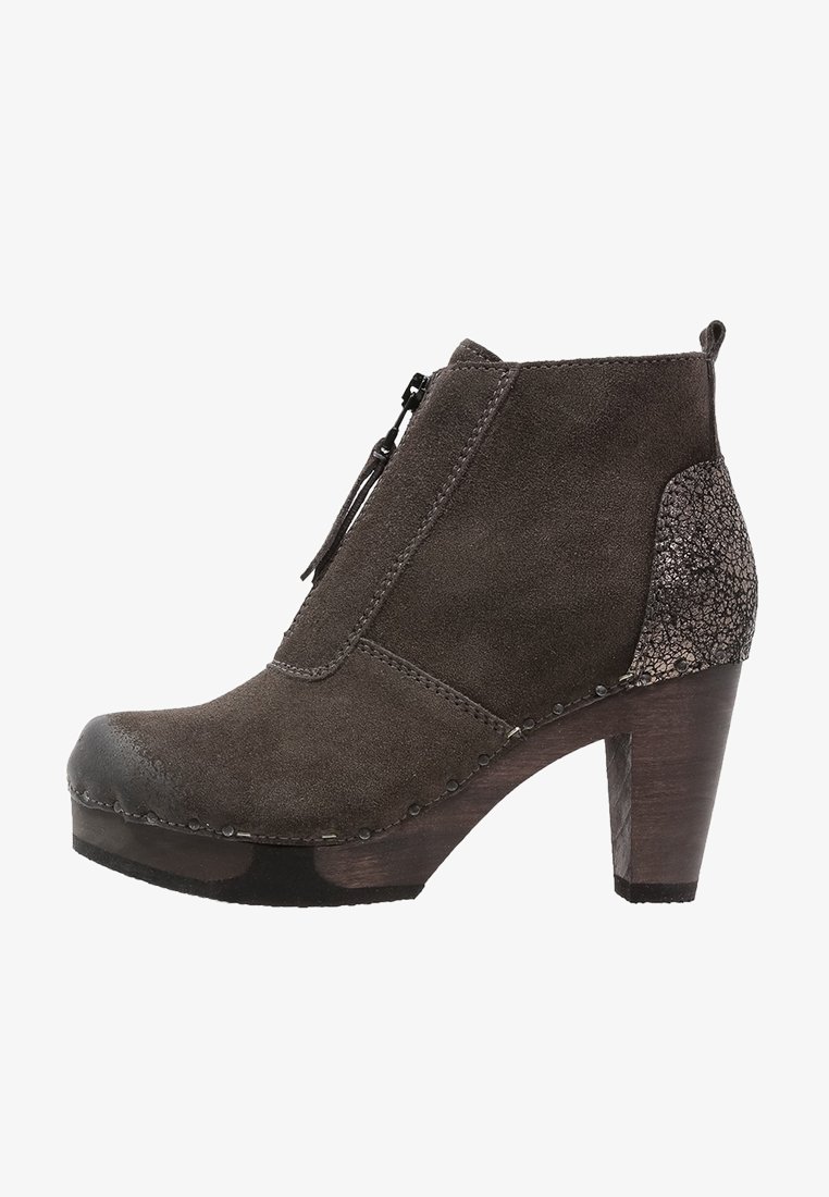 Bottine en suède gris foncé avec talon bloc en bois, fermeture éclair latérale et contrefort de talon métallique texturé.