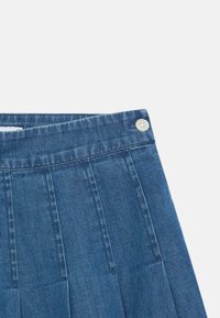 Μπλε τζιν ύφασ μα, με επίπεδη μέση που έχει κουμπί, κατακόρυφες πτυχές και λεία υφή, σχεδιασμένο για σφιχτή εφαρμογή.