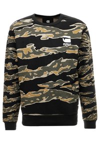 Svettröja i kamouflage-mönster i svart, grönt och tan. Har rund halsringning och en vit "RAW"-logotyp på bröstet. Långa ärmar.