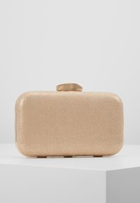 Clutch beige hecho de un material texturizado con una superficie lisa. Cuenta con un cierre dorado y tiene forma rectangular.