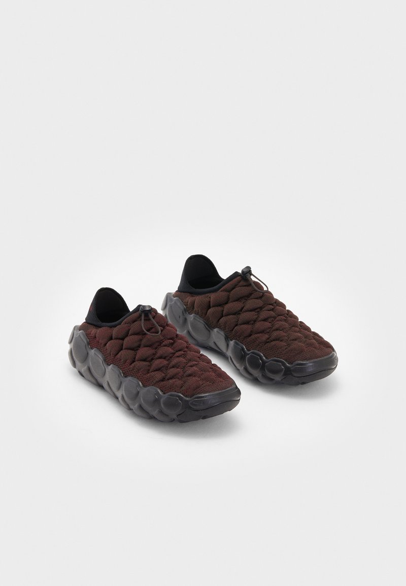 Quiltet burgunder sneakers med sort gummi såle, elastiske snørebånd og et sømløst design som gir et teksturert og dempet utseende.