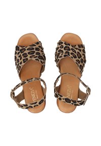 Sandalen mit Leopardenmuster, überkreuztem Design, aus Wildleder, mit ankle-buckle und einem beigen Lederfußbett. Mit schwarzen und braunen Flecken.