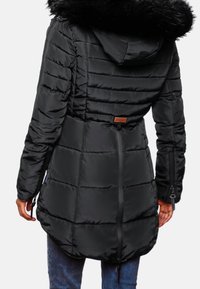 Svart vadderad parka med huva i fuskpäls, med horisontell quiltning, dragsko i midjan och sidofickor med dragkedja. Läderetikett på ryggen.