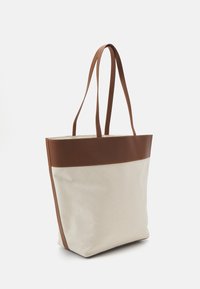 Plátěná taška s hnědým koženým lemováním. Disponuje dlouhými popruhy, obdélníkovým tvarem a hladkým povrchem. Barva je krémová s tmavě hnědými akcenty.