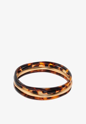 Nałożone bransoletki z naprzemiennym wzorem imitującym skorupę żółwia i gładkimi, złotymi paskami na białym tle.