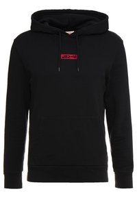Sweat à capuche noir avec une poche avant kangourou, une capuche ajustable et un logo rouge rectangulaire cousu sur la poitrine. Le tissu semble doux et texturé.
