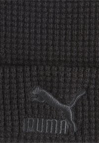 Berretto in maglia nera con texture a coste, caratterizzato da un discreto logo Puma ricamato in nero frontale.