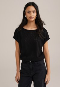 Mustard värvi lühikeste varrukatega pluus, millel on chevron muster, ümar kaelus ja mugav lõige. Sobib tumedate kõrge vöökohaga teksadega.