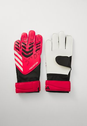 Guantes de portero rojos y negros con agarre texturizado, dedos acolchados y correa ajustable en la muñeca. Palma blanca con detalles negros y logo.