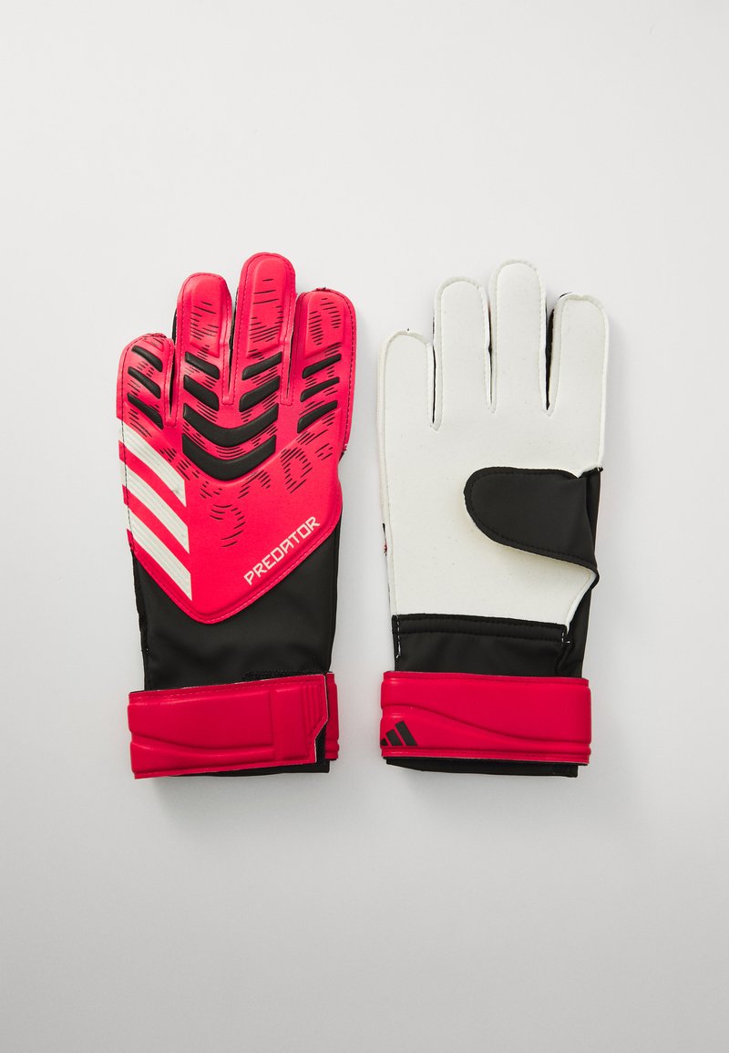 Gants de gardien de but rouges et noirs avec une prise texturée, des doigts rembourrés et une sangle de poignet réglable. Paume blanche avec accents noirs et logo.