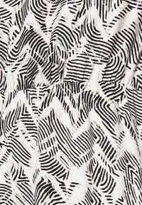 Μαύρος και άσπρος ύφασμα με γεωμετρικό σχέδιο κυμάτων με εναλλασσόμενες χοντρές και λεπτές γραμμές. Λείος υφασμάτινος σχεδιασμός, συγκεντρωμένος στη μέση.