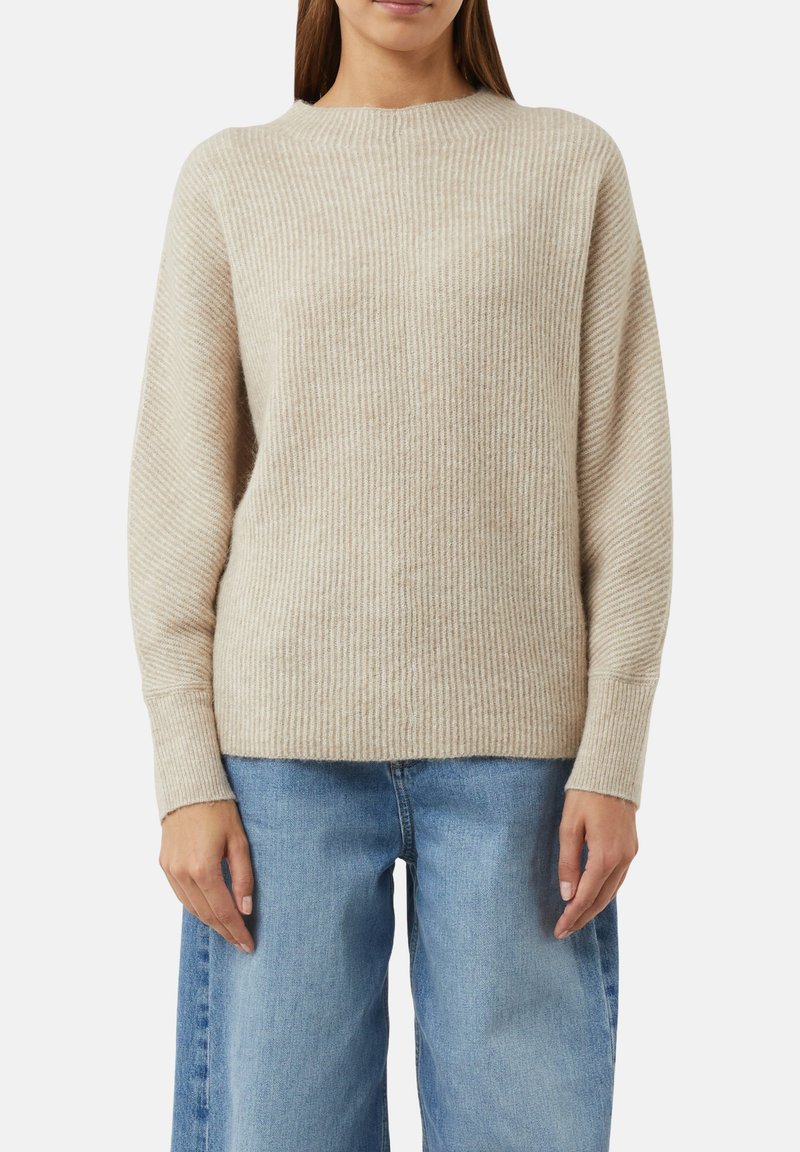 Beżowy sweter w prążki wykonany z miękkiego materiału dzianinowego. Posiada okrągły dekolt i długie rękawy. Połączony z jasnoniebieskimi spodniami o szerokich nogawkach.