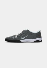 Sapatilha de futsal Nike Total90III em cinza e preto, com sola branca, atacadores brancos e logótipo swoosh azul claro de lado.