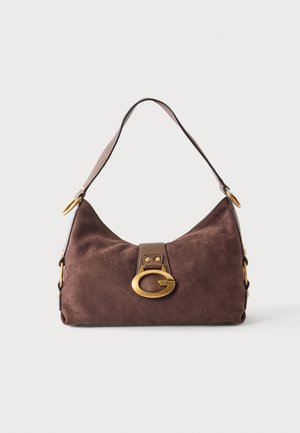 Sac à bandoulière en daim marron avec une large sangle et une grande boucle ovale dorée sur le devant, sur un fond clair uni.