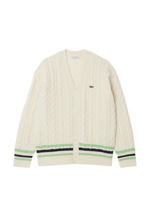 Cable-knit cream cardigan with a V-neck, green and navy stripes at the hem, and a small Lacoste logo on the left chest. Six buttons down the front.