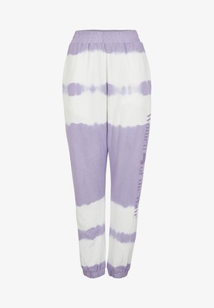 Fioletowo-białe spodnie dresowe tie-dye z elastycznym pasem i ściągaczami, z pionowym napisem „Women of the Wave” na jednej nodze.