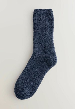 Marineblå, bløde, fuzzy sokker lavet af plys-materiale; har en rund tå og en ribbet manchet øverst. Egnet til afslappet brug.