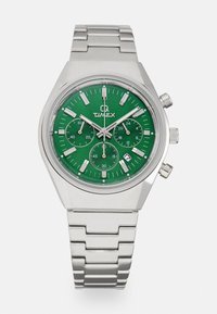 Timex-Uhr mit grünem Zifferblatt, gehäuse und armband aus silbernem edelstahl, mit drei unterziffern, silbernen stundenmarkierungen und datumsanzeige.