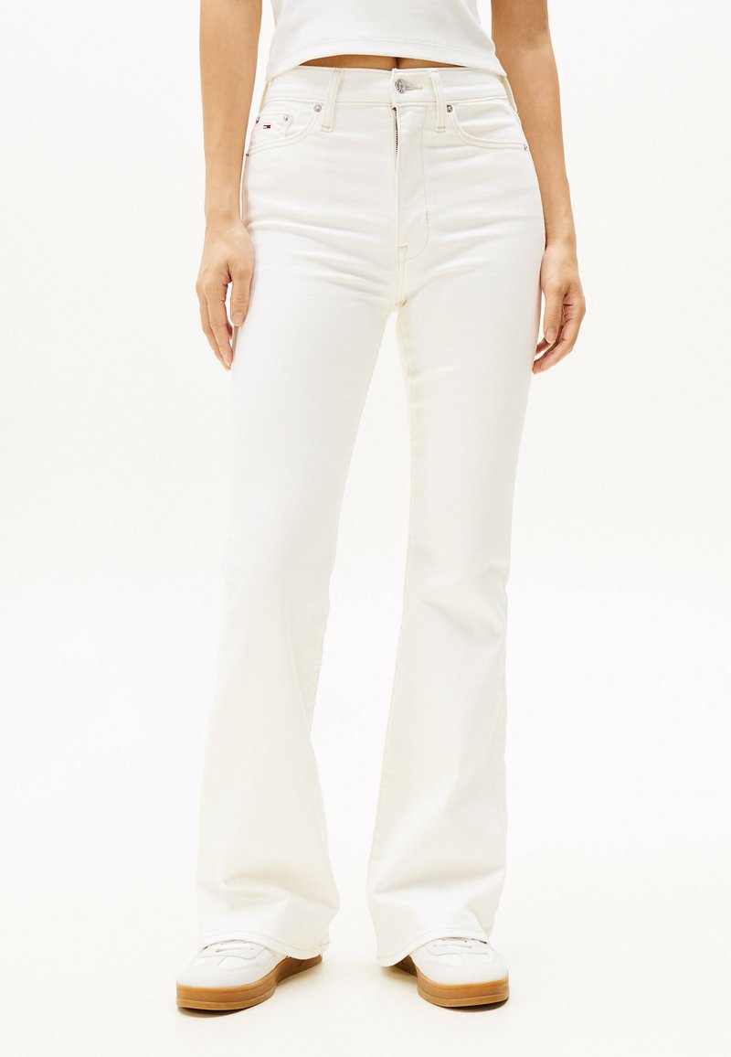Pantalones vaqueros acampanados blancos hechos de una mezcla de algodón. Presentan un cierre de botón y cremallera, cinco bolsillos y una textura lisa y sin adornos.