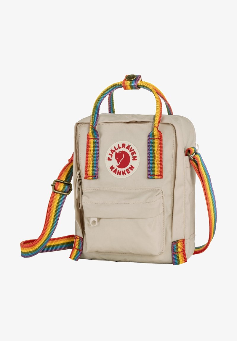 Bolsa Kanken de Fjällräven en color beige con un asa y una correa de hombro a rayas de colores, que cuenta con un bolsillo frontal y un parche de logo circular.