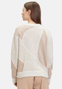 Pullover mit geometrischem Design in Beige und Creme, aus weichem Strickmaterial mit strukturierten Akzenten und rundem Ausschnitt.