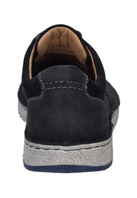 Černá kožená volnočasová obuv s texturovaným svrškem, béžovou podšívkou a bílou gumovou podrážkou. Šití podél švů.