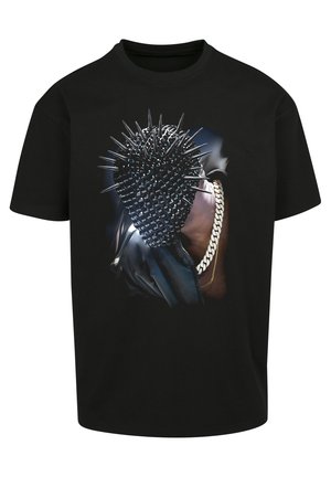 T-shirt noir avec un graphique de tête épineuse et un accent chaîne. Manches courtes et coupe classique. Design audacieux avec une texture brillante.