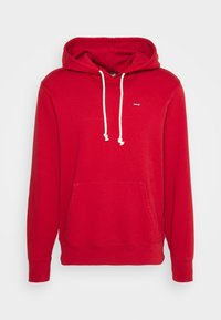 Sweat à capuche rouge avec cordons blancs, poche avant et petit logo Levi's sur le côté gauche de la poitrine, présenté sur un fond uni.