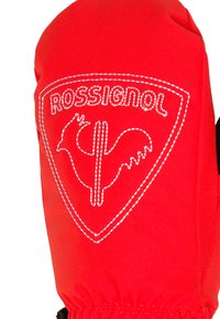 Červené lyžařské palčáky vyrobené z měkké tkaniny, se zdobeným bílým logem ve tvaru štítu a elastickým zápěstím pro bezpečné uchycení.