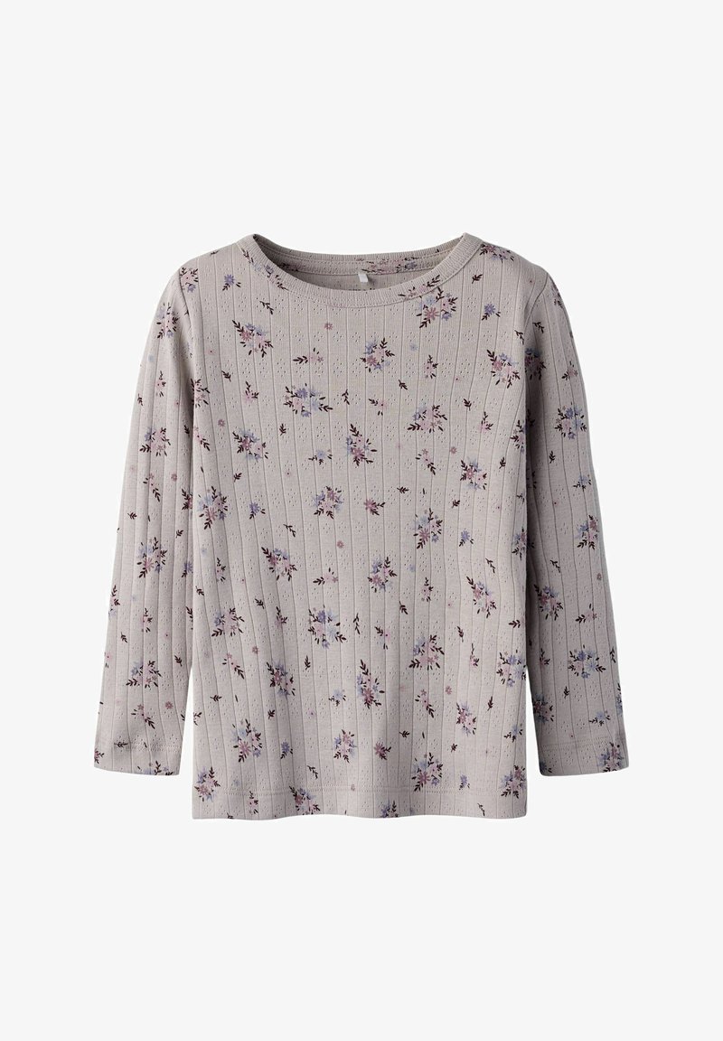 Jasnoszara bluzka z długim rękawem o prążkowanej fakturze, z kwiatowym wzorem w odcieniach fioletu i różu. Okrągły dekolt i luźny krój.