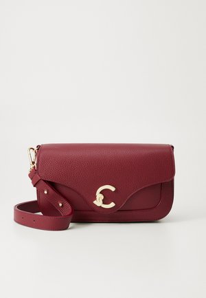 Ciemnoczerwona torebka skórzana na ramię z teksturą, z złotym zakrzywionym zapięciem i regulowanym paskiem zwiniętym obok na jednolitym tle.