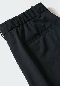 Černé kalhoty s elastickým pasem, které mají zadní kapsu s jemným lemováním a hladkou texturou látky.